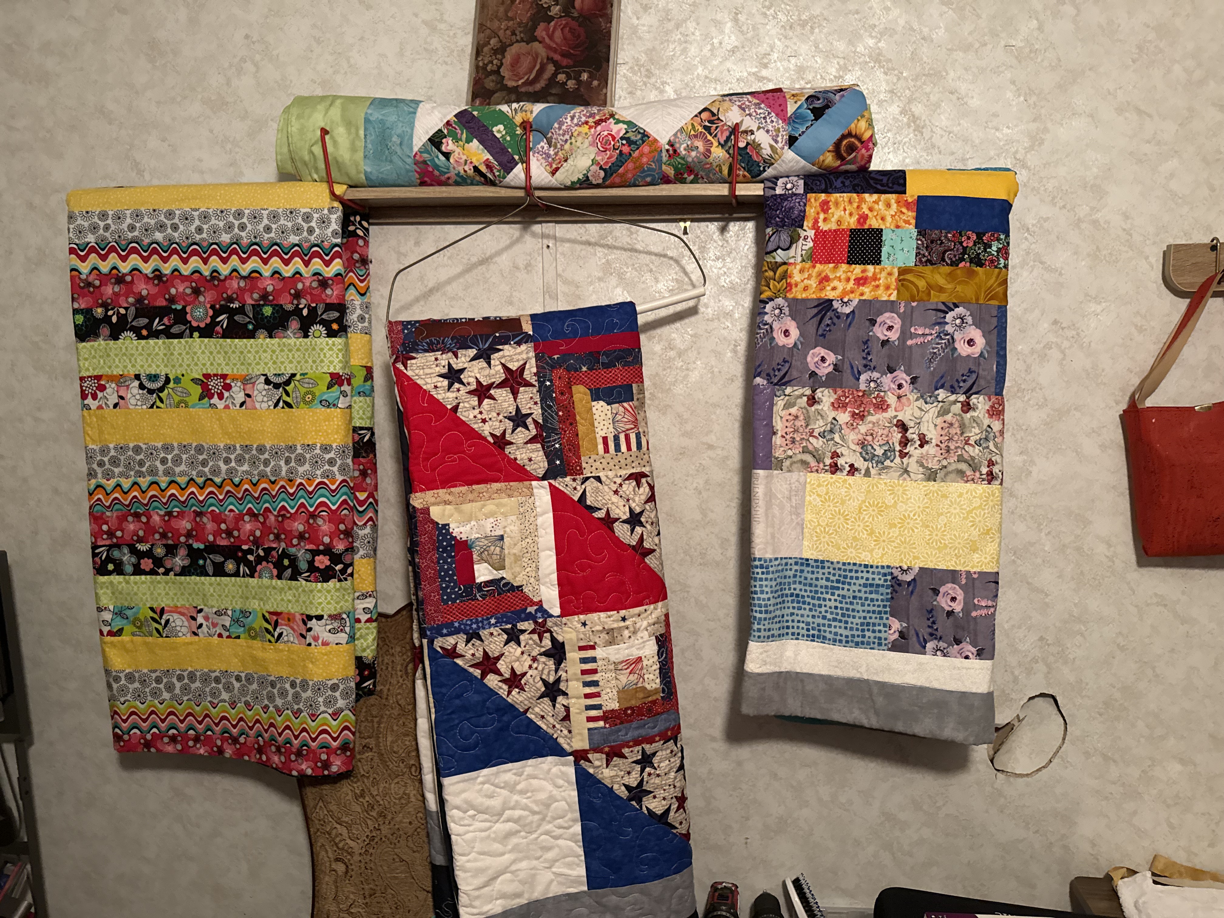 Three handmade quilts hanging