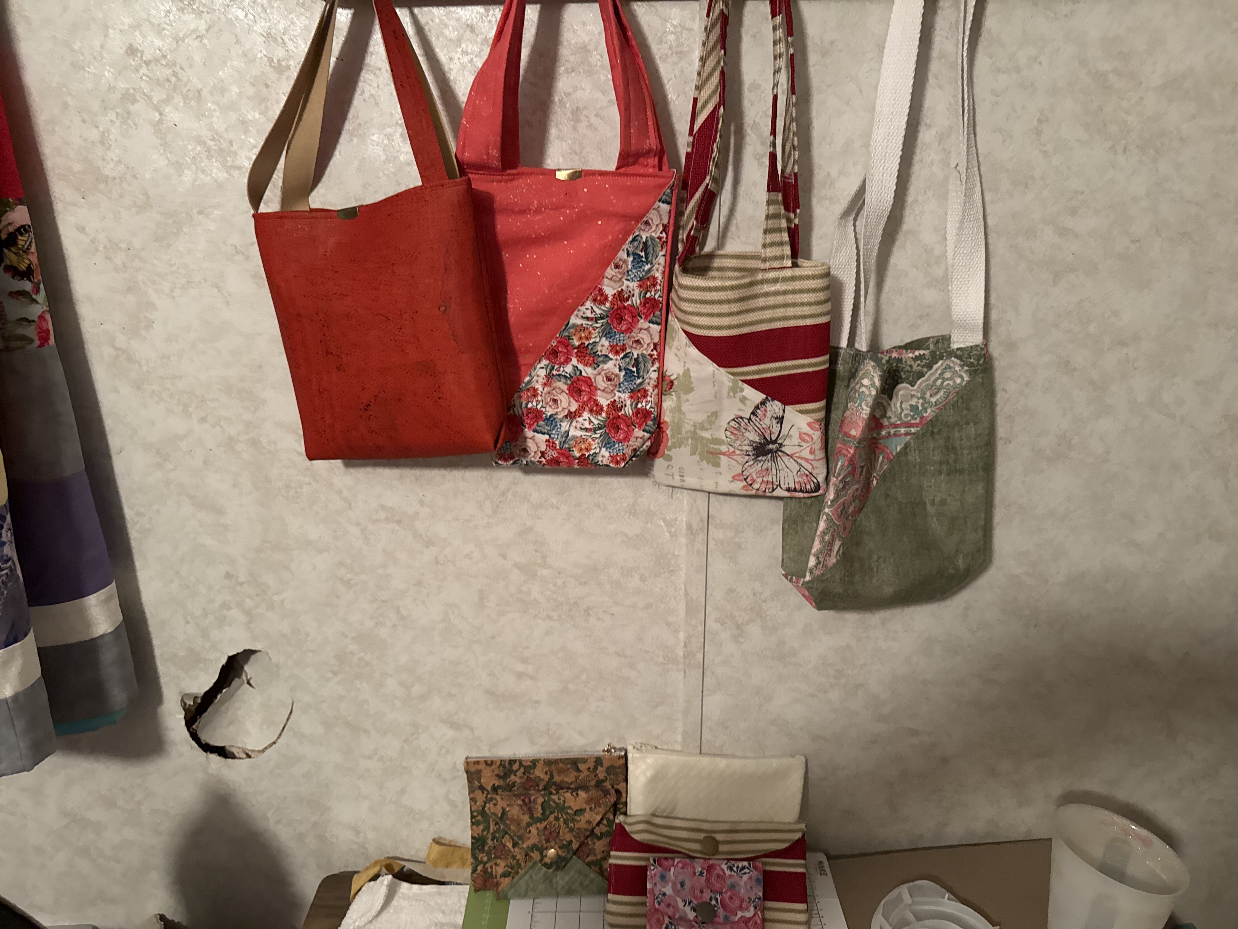 Handmade fabric tote bags hanging in the studio